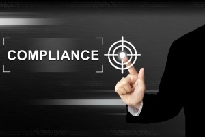 business hand pushing compliance button on touch screen